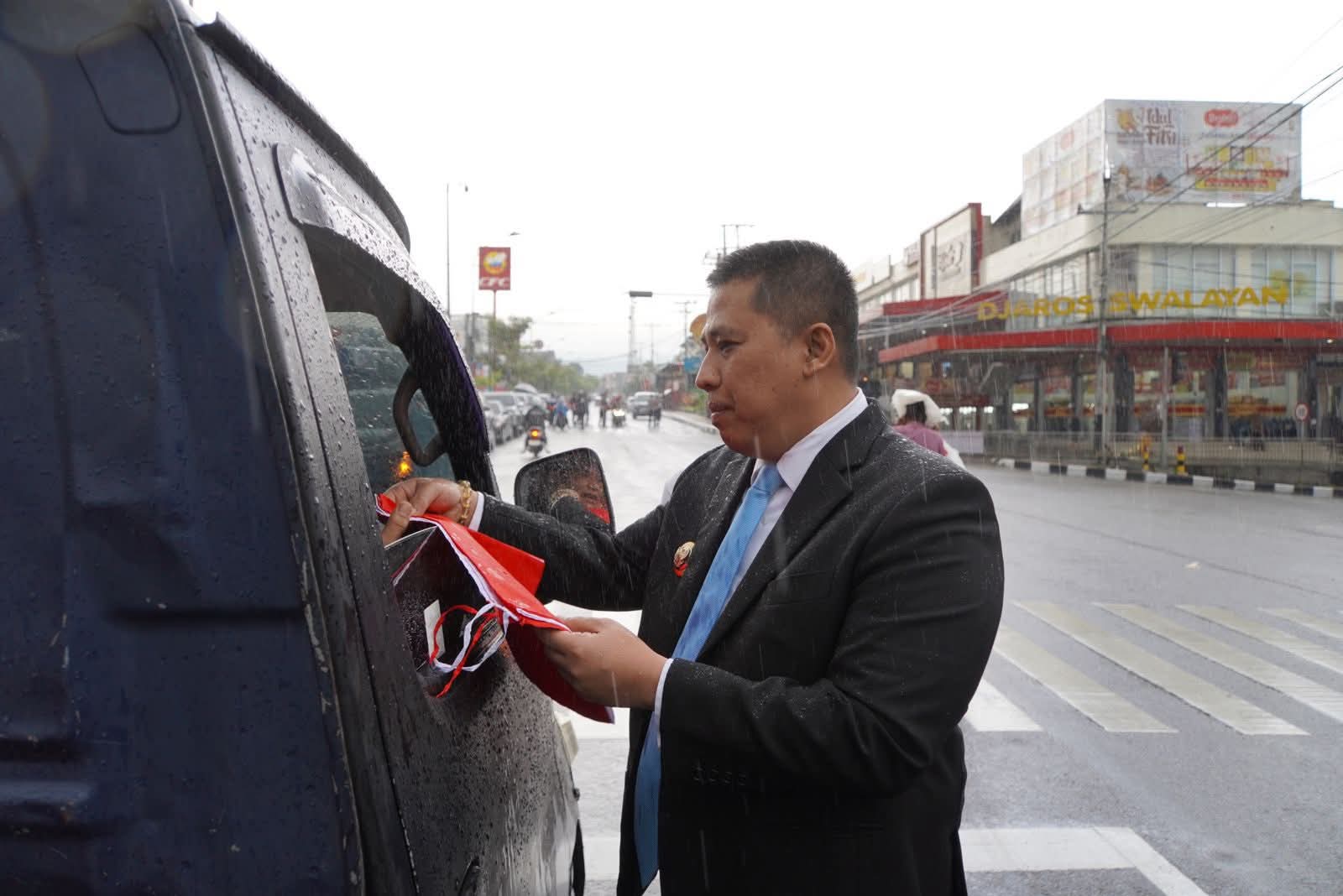 Wako Hendri Arnis saat bagikan bendera merah putih pada salah seorang pengemudi kendaraan